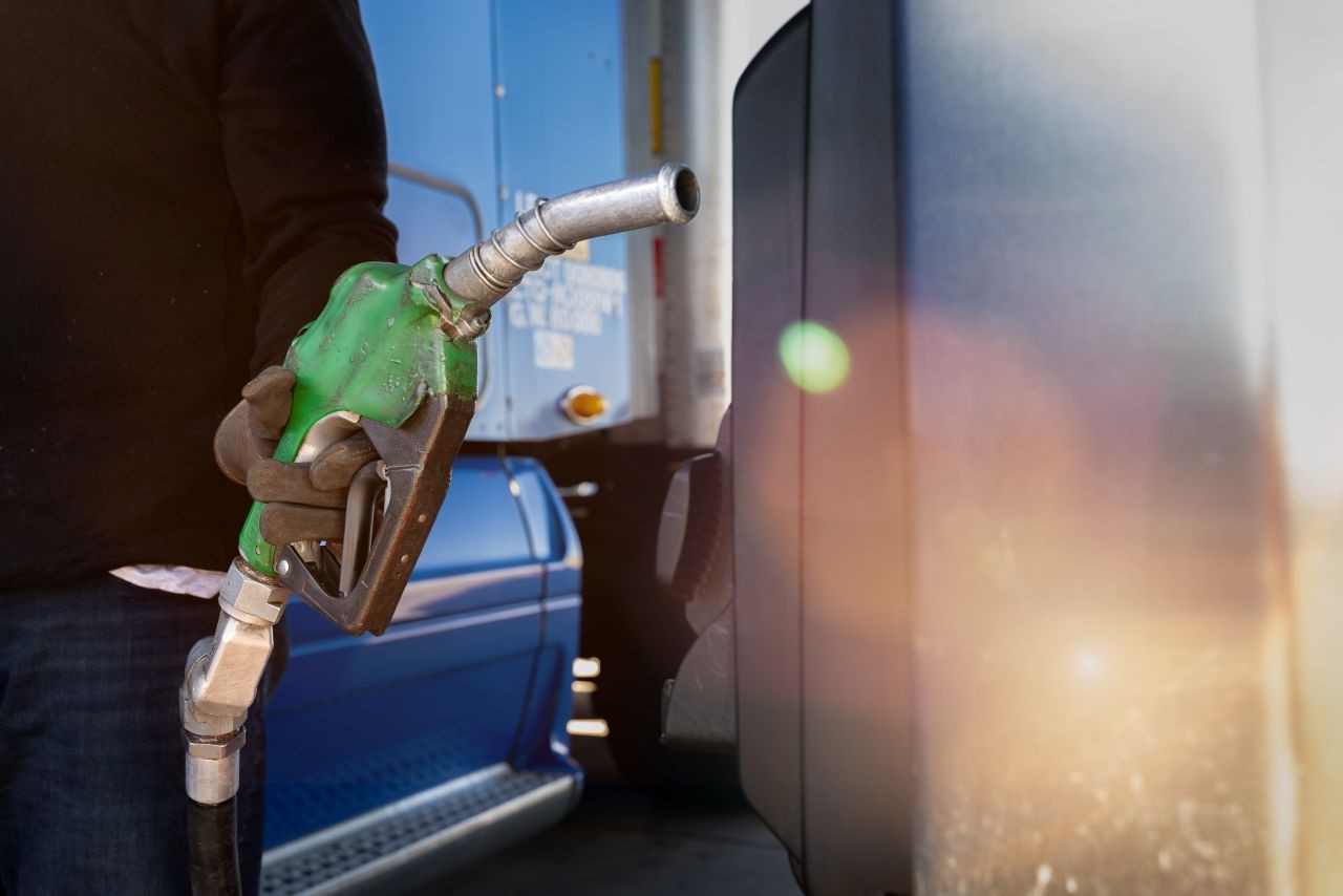 close up of a driver removing a fuel nozzle from the pump