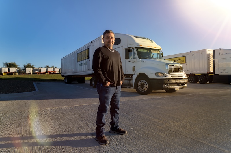 driver standing in front of a truck with a j.b. hunt intermodal container attached